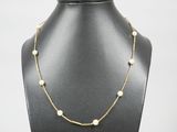 a gold necklace with pearls on a mannequin neck