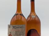 deux bouteilles de vin sont posées l'une à côté de l'autre sur une surface blanche