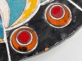 a close up of a colorful plate on a white surface
