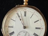a gold pocket watch with roman numerals on it