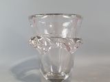 a clear glass vase with a leaf decoration on it