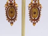 gold plated earrings with a picture of a woman and a bird