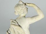 a white statue of a woman with her hand on her head