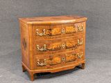 an antique chest of drawers with a wooden top and brass handles