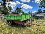 une remorque verte garée dans l'herbe