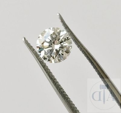 un gros plan d'un diamant tenu par une paire de pinces