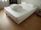 a white bed with two pillows on top of it