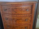a wooden chest of drawers with a mirror in the corner