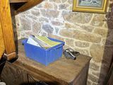 a wooden table with a blue box on it in the corner of a room