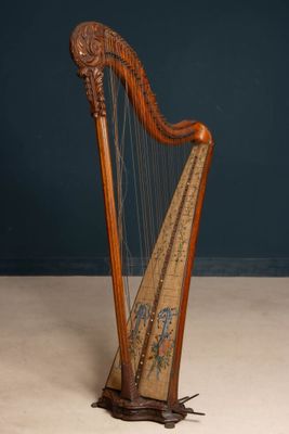 an old wooden harp sitting on top of a floor next to a blue wall