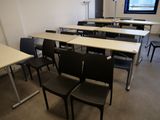 des rangées de pupitres et de chaises dans une salle de classe, avec une fenêtre en arrière-plan
