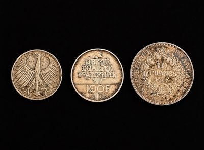trois pièces allemandes, une en argent et une en or, sur fond noir