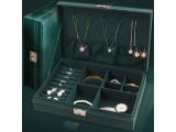 a green case with jewelry inside of it on a table