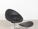 an image of a black chair and ottoman in a white room