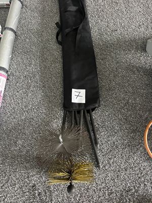 un balai, une brosse et d'autres objets par terre