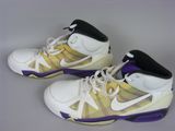 pair of white and yellow sneakers with purple accents on a gray surface