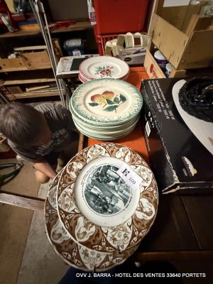 a boy that is looking at some plates on a table
