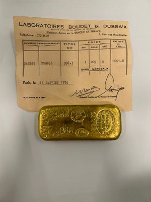 a gold bar sitting next to a receipt on top of a table
