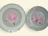 deux assiettes ornées de fleurs roses, posées sur une table