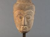 statue représentant une tête humaine coiffée d’un chapeau
