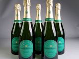 four bottles of champagne are lined up in a row
