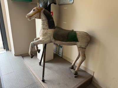 a wooden horse with a helmet on it ' s head