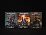 trois livres consacrés à Warhammer et Kill Team sur fond noir