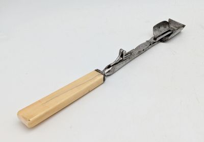 un vieux marteau avec un manche en bois posé sur une surface blanche