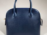 a blue leather handbag on a white background