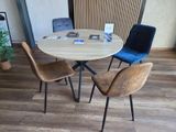 quatre chaises disposées autour d'une table ronde sur laquelle se trouve un magazine