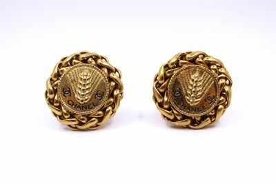a pair of gold earrings with a lion head on the front and a lion head on the back
