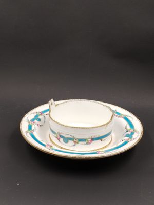 un gros plan d'une tasse et d'une soucoupe posées sur une surface noire