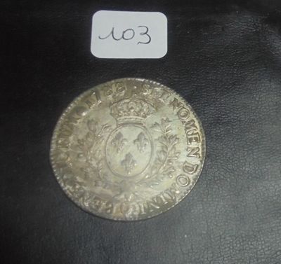 une pièce d'argent sur laquelle figure une couronne, posée sur un fond noir