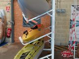 Plusieurs kayaks sont empilés les uns sur les autres dans un entrepôt