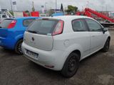 a small white car parked in a parking lot next to a blue car