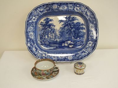 une assiette bleue et blanche, avec une tasse et une soucoupe à côté