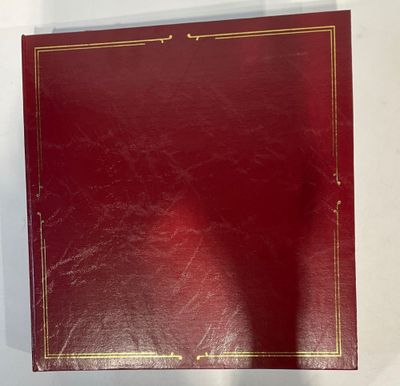 un classeur rouge avec des finitions dorées et une bordure dorée