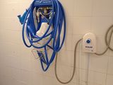 a blue hose attached to a wall in a bathroom