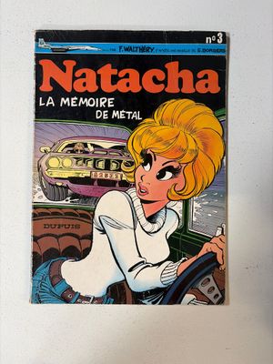 un gros plan sur un livre posé contre un mur, avec une voiture en arrière-plan