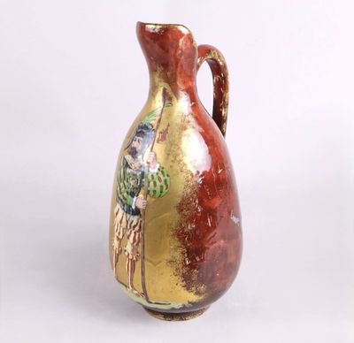 un vase rouge et doré posé sur une surface blanche