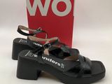 une paire de sandales noires pour femme, avec une boîte rouge en arrière-plan