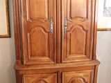 a large wooden armoire in the corner of a room