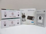 three boxes of baby monitors sitting on top of a white table