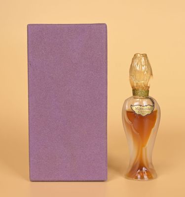 un flacon de parfum posé à côté d'une boîte violette sur une surface beige