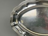 a silver tray with a silver handle on a table