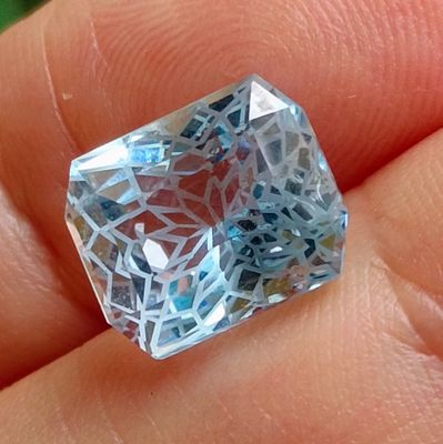 a person holding a very pretty blue diamond in their hand