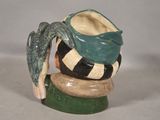 a ceramic sculpture of a bird sitting on a stack of bowls
