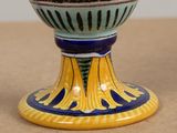 a blue and yellow vase sitting on a table