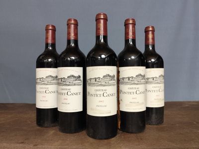 four bottles of red wine are lined up on a table
