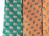 four different colored neck ties are lined up on a white surface